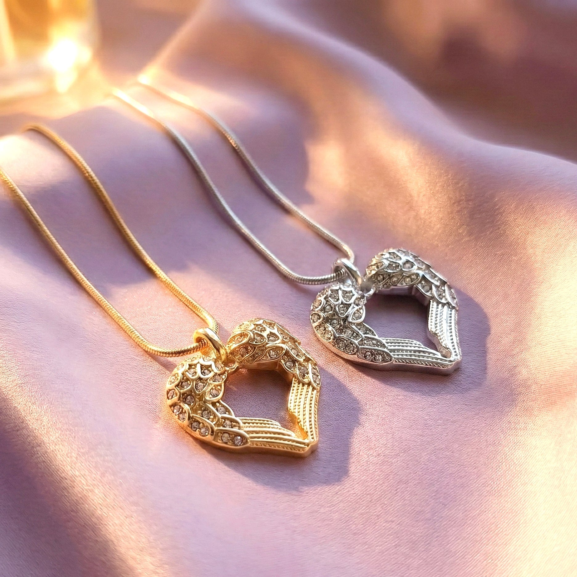 Belle Fever silver and gold angel heart necklace on purple fabric handcrafted symbolic jewellery representing love and protection