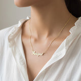 Belle Fever Gold Name Necklace worn close to the heart — a personalised pendant celebrating your name, your story, and your most meaningful connections.
