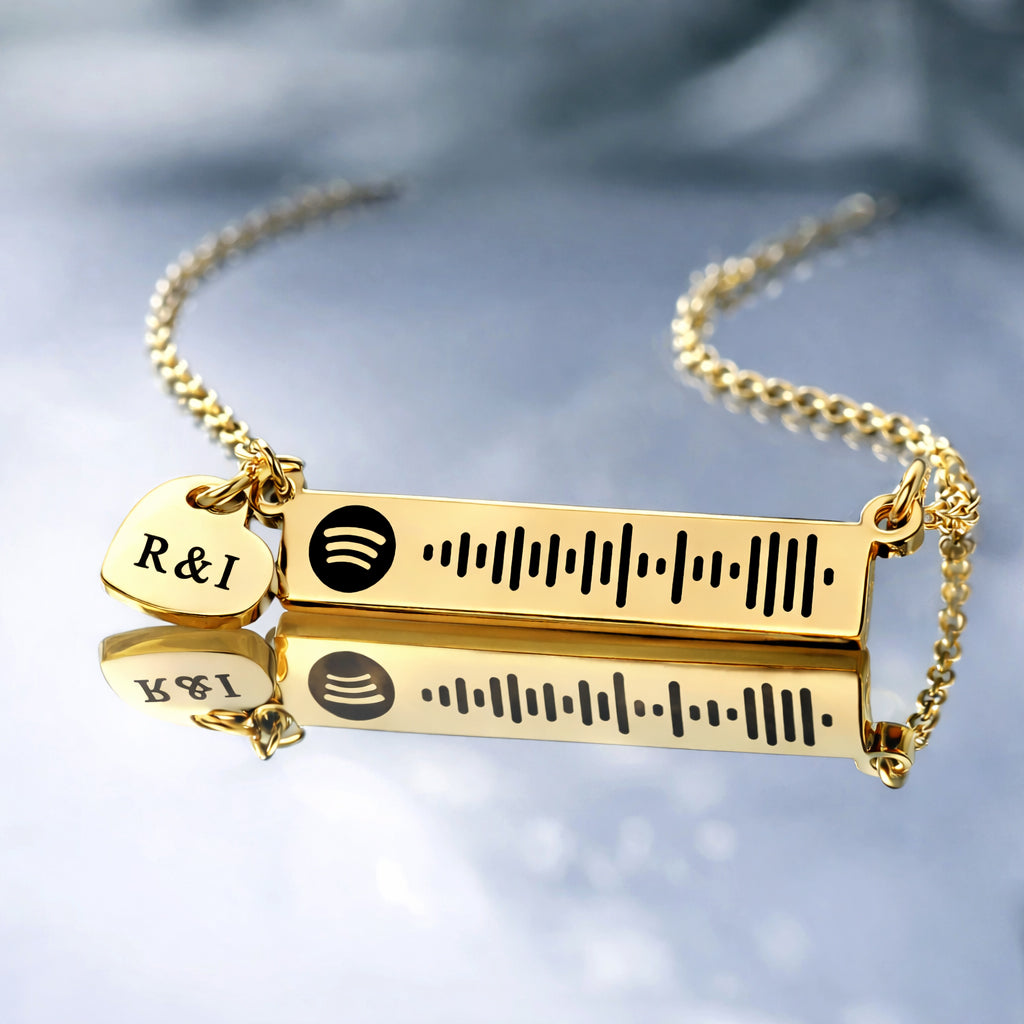 Gold personalized music bar necklace featuring an engraved song code and heart charm, Belle Fever design