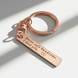 Belle Fever rose gold reminder tag keychain close-up, engraved bar keepsake with smooth finish, thoughtful gift for loved one