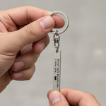 Belle Fever silver reminder tag keychain held in hand, custom engraved bar keepsake with personal message, everyday carry gift