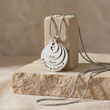 Belle Fever Tower of Love necklace with multiple engraved disc charms, styled on a natural stone surface