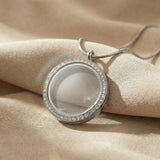 Dream locket necklace in silver with round glass pendant in neutral background 