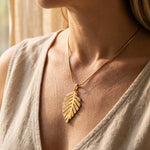 Woman wearing family leaf necklace, elegant personalised jewellery for mum and family keepsake gift