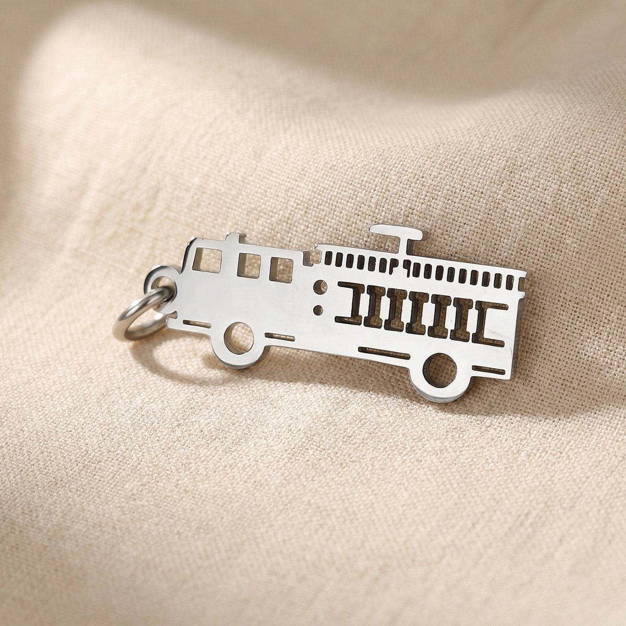 Silver fire truck charm for keyring honoring firefighters, bravery, and emergency service dedication