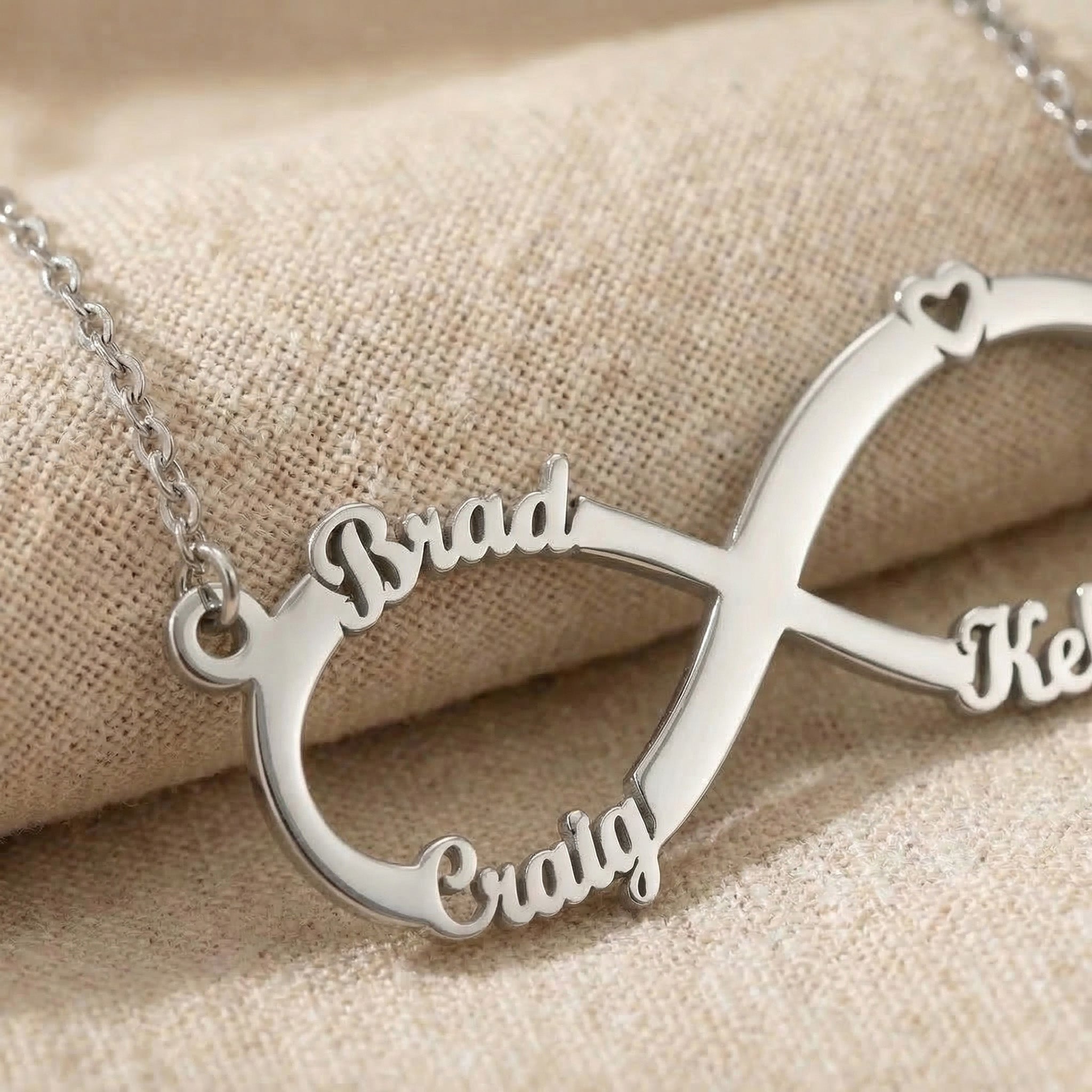 Close-up of classic infinity name necklace showing custom name cut-out detail in polished finish