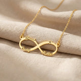Gold infinity name necklace with custom name on infinity pendant displayed on neutral background