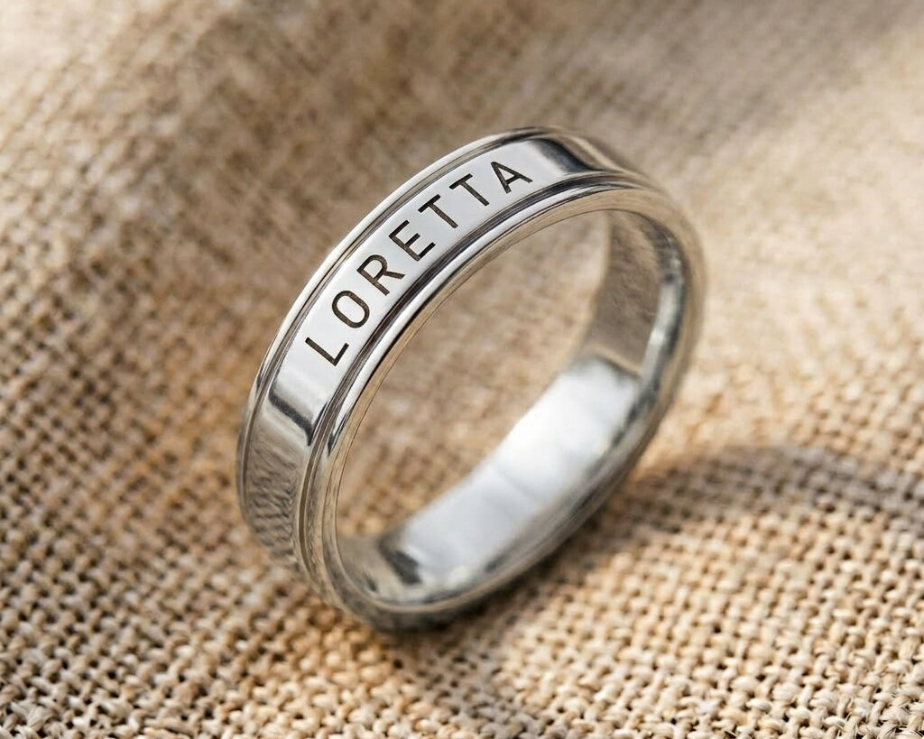 Silver personalised band ring with engraved name detail, minimalist custom jewelry close-up