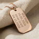 Close-up of personalised dog tag necklace with engraved message showing fine detail and finish