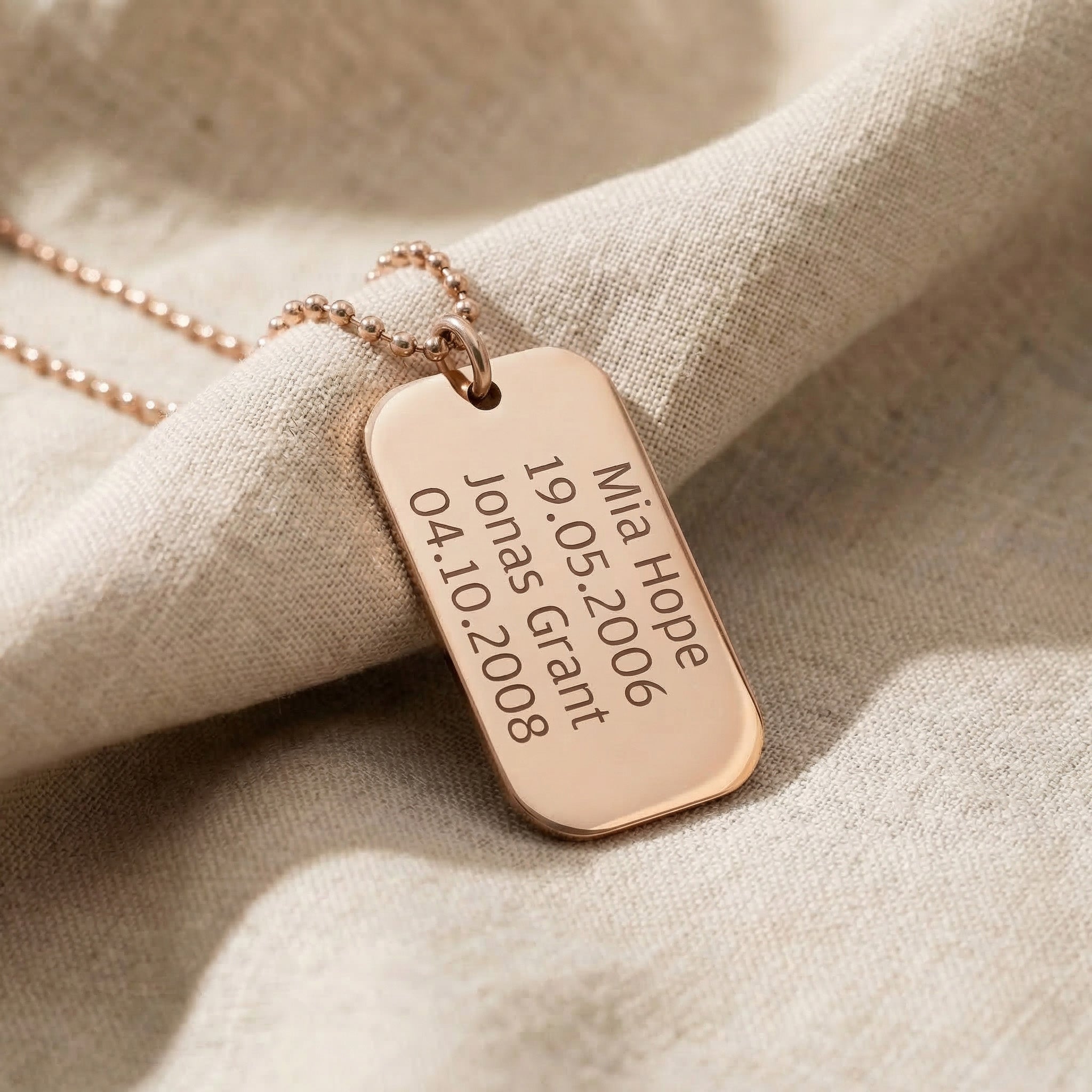 Personalised dog tag necklace in rose gold with engraved text, elegant custom jewelry piece