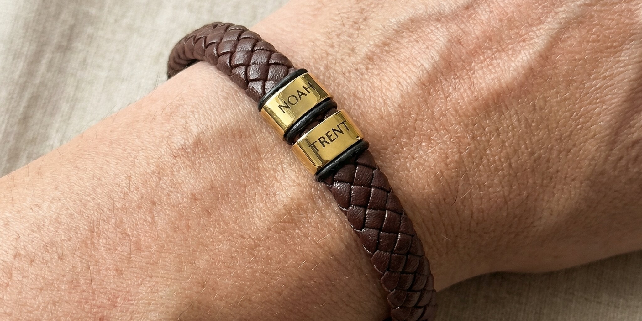 Personalised brown leather bracelet with engraved gold charms, custom design option