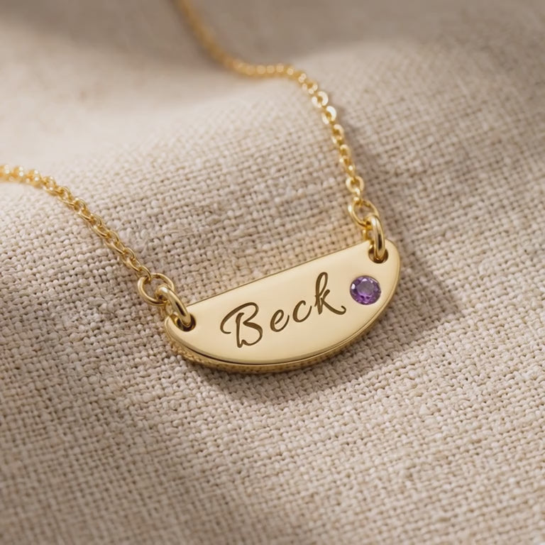 Product video showing beck name necklace with engraved bar pendant and birthstone detail