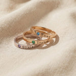 Stackable rings set with engraved names and decorative stones, layered ring design